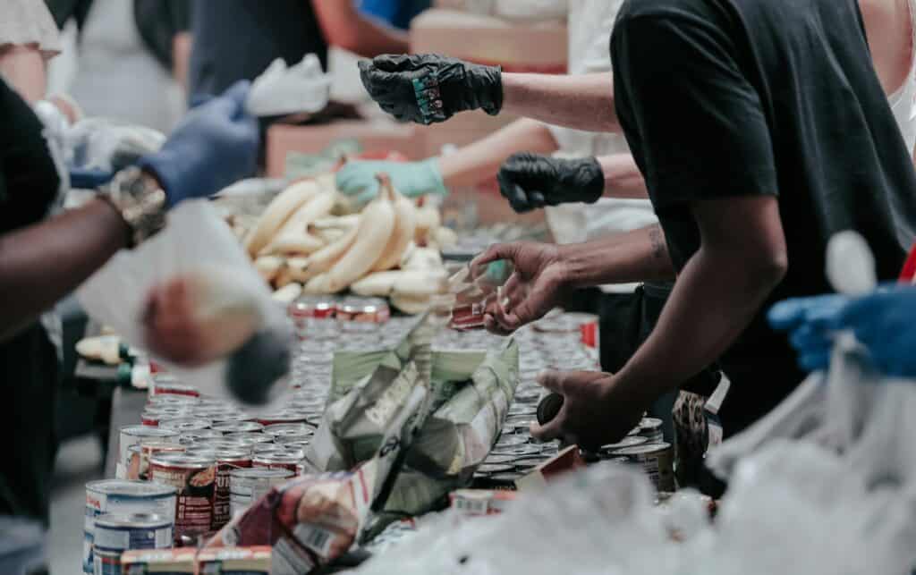 Hands in rubber gloves giving out food