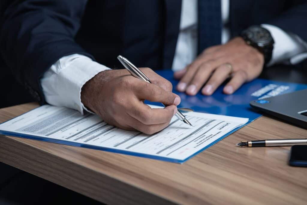 Man in suit signing paperwork