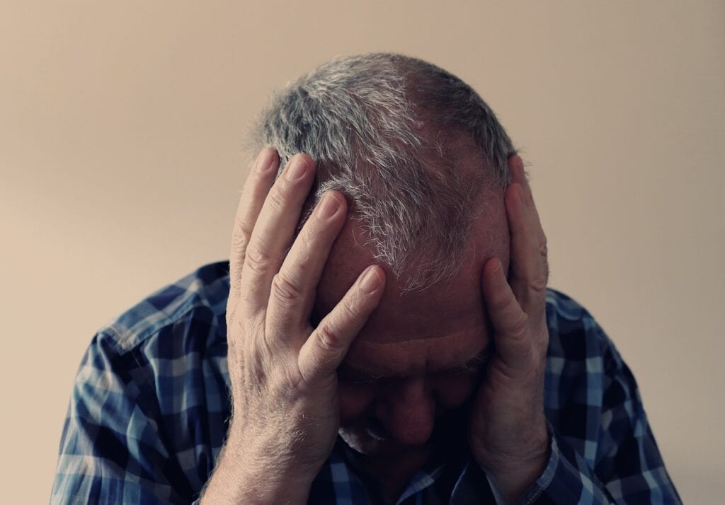 older man with head in hands