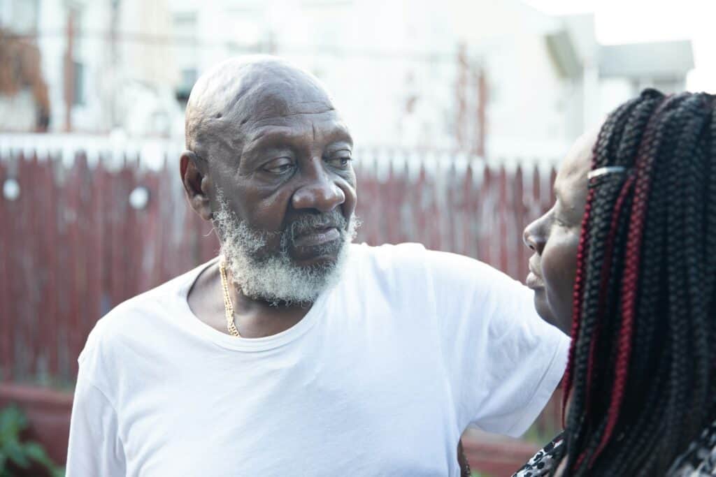 man and daughter talking in yard