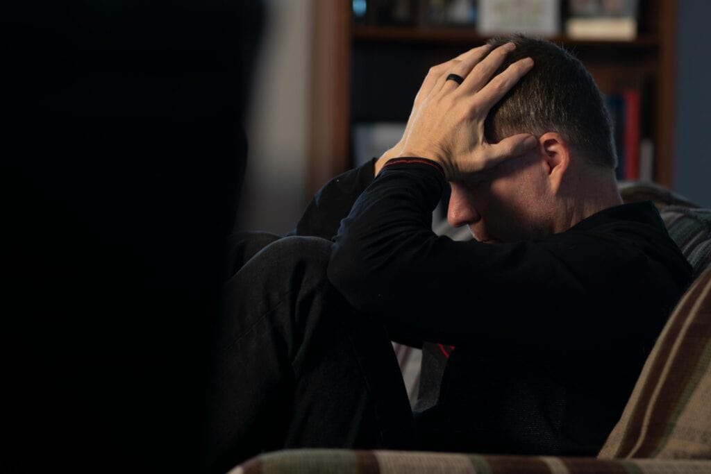 man hands on head upset