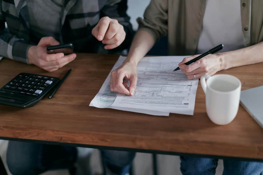 hands of couple doing budget calculator paperwork