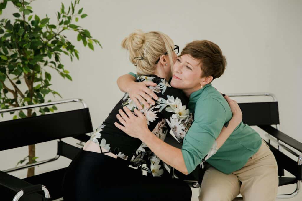 women hugging helping comforting