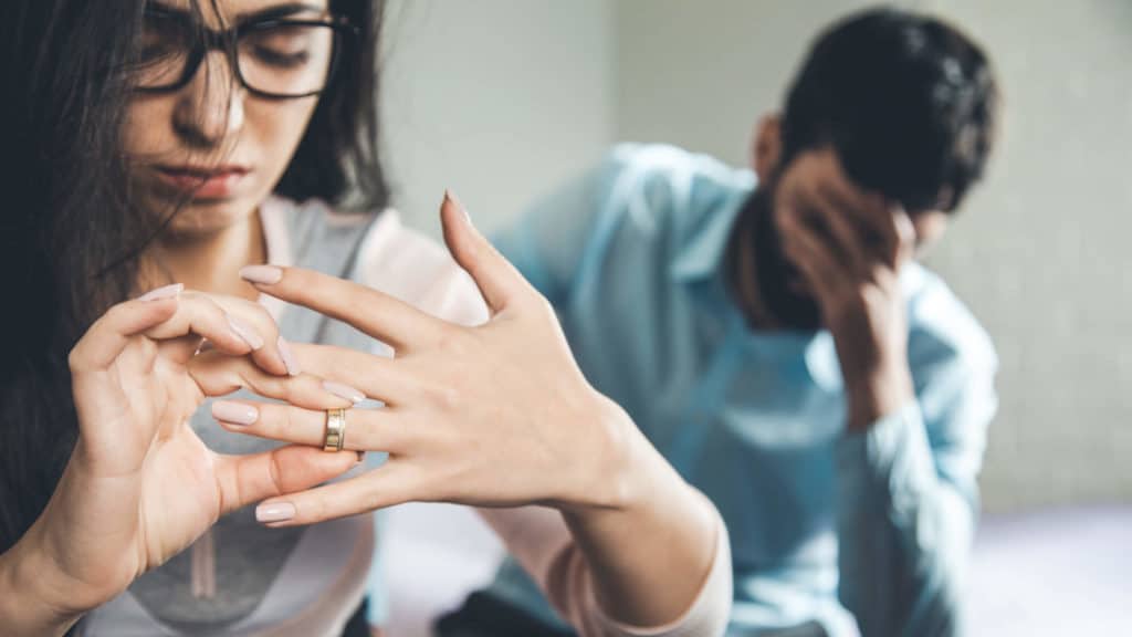 wife removing wedding ring to signal divorce